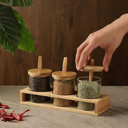 Cp Glass Triple Condiment Jar and Spoon with Wooden Stand (Spoon-13 * 3 * 0.4cm/Glass with lid-6.5 * 6.5 * 9.5cm/Stand- 24.5 * 8 * 4cm)